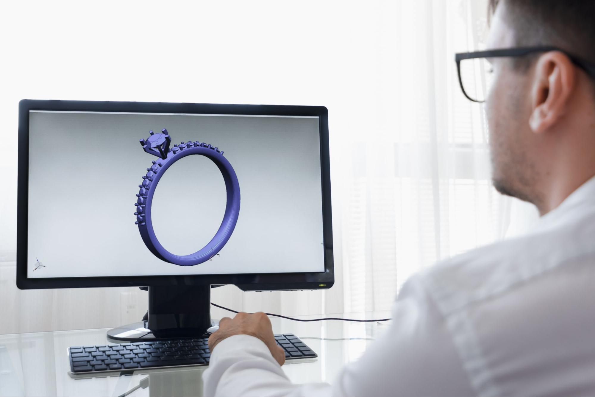 a jeweler custom designing an engagement ring on a computer