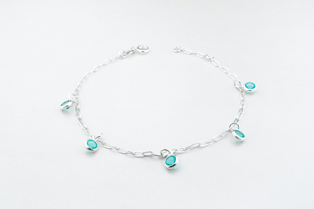 a white gold chain bracelet with station set blue gemstone charms