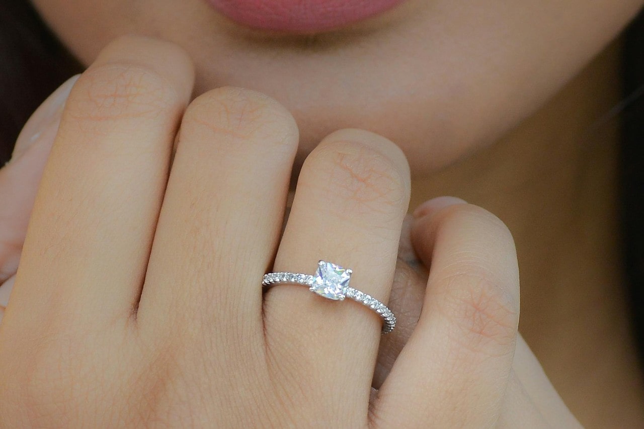 A focus on a woman’s platinum engagement rings with diamonds around the shining band